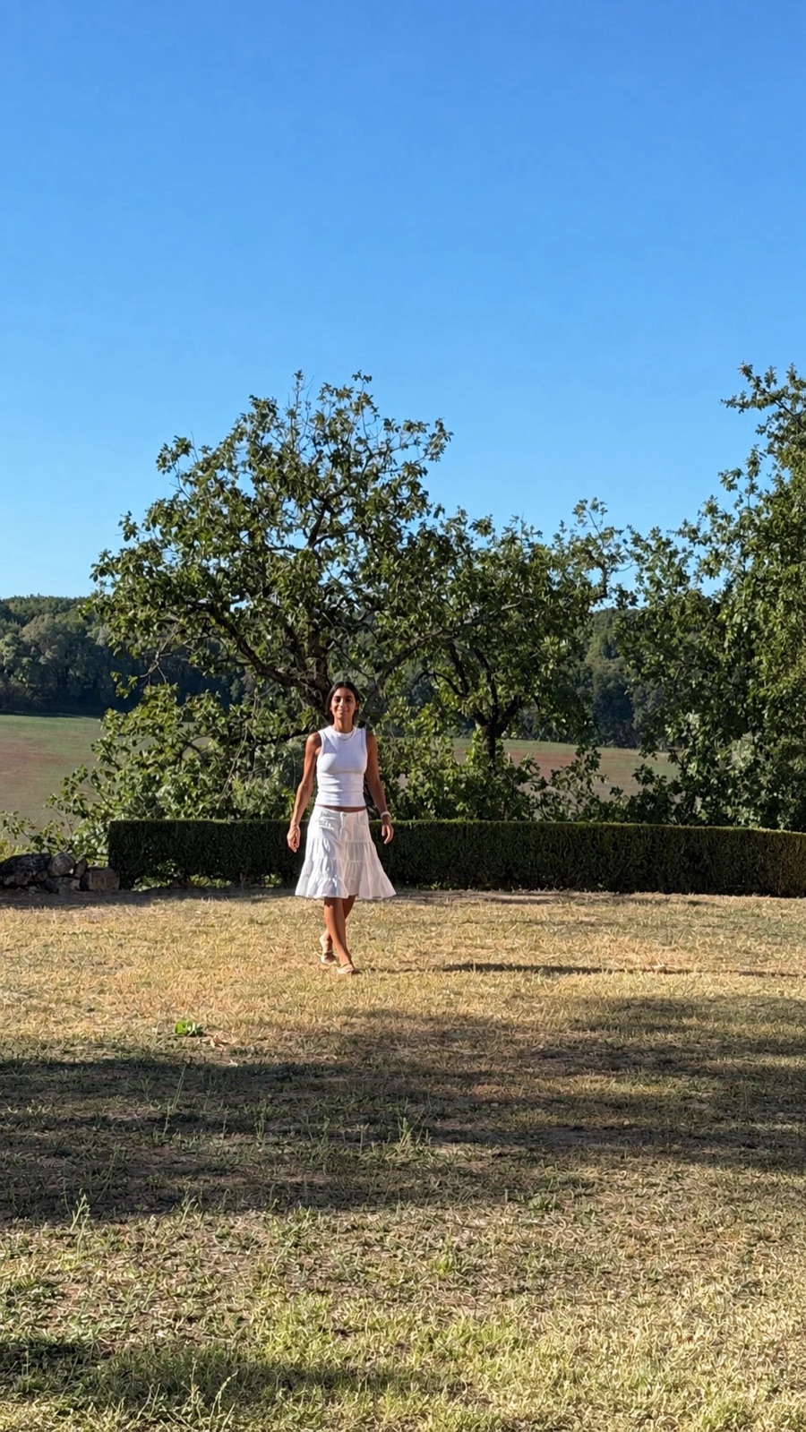 María Alejandra caminando por un jardín en verano